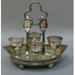 A George III style navette-shaped egg frame with pierced gallery, four conforming egg cups, the
