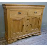An oak buffet, the rectangular top above an ogee moulded frieze fitted with two short drawers