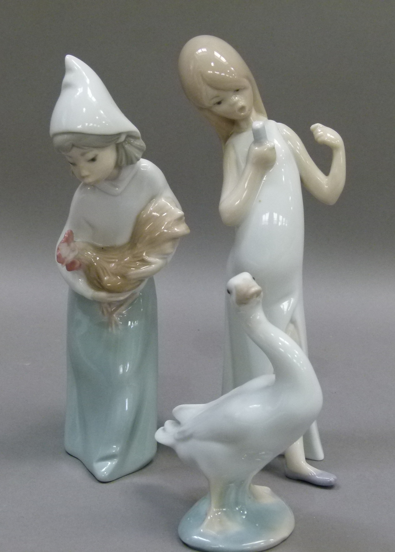 A Lladro figure of a young girl carrying a cockerel, 19cm high, printed mark in blue; another Lladro