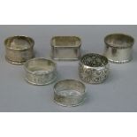 Six silver napkin rings, one floral embossed engraved and dated 1902, three other circular and a