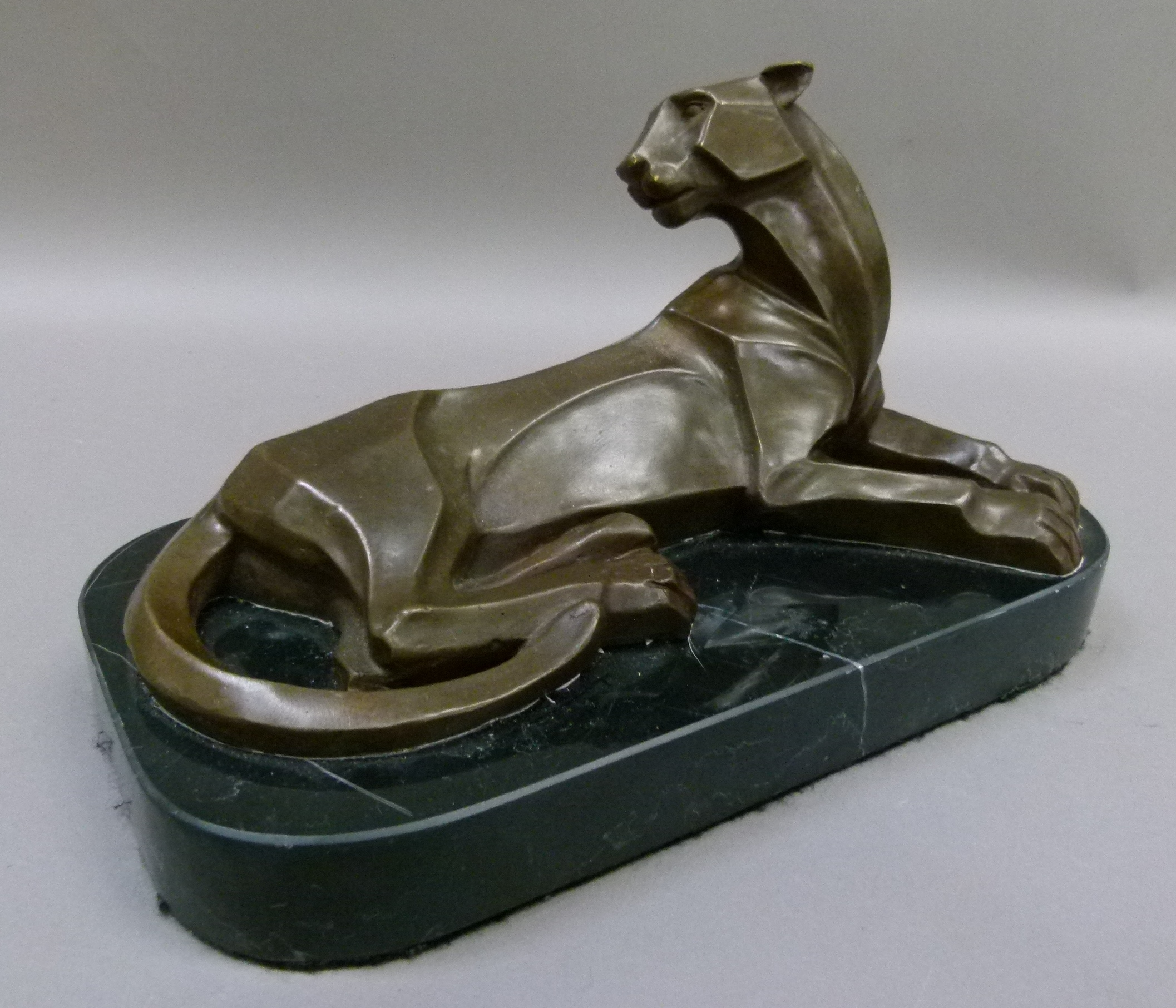 A reproduction bronze model of a panther on black marble base, 29cm wide