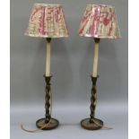 A pair of oak barley twist table candle sticks, fitted for electric light with faux candles and