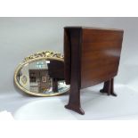 A mahogany stained drop leaf kitchen table; a reproduction gilt plaster oval wall mirror with