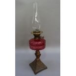 A late Victorian bronze effect cast iron oil lamp, the base cast dragons, leafage and scaling,