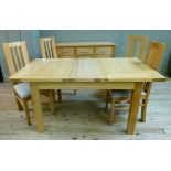An oak extending dining table, together with a set of four rail back dining chairs with oatmeal