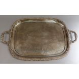 A silver plated two handled tray with floral and shell cast border, the field engraved with fruit,