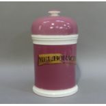 A Victorian pottery drug jar, the cylidrical pink body with white moulded borders with gilt banner