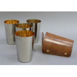 A set of four silver plated tumblers with silver gilt interiors in a leather carrying case