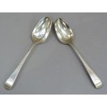 A pair of George III silver table spoons with bright cut decoration to the handles with oval