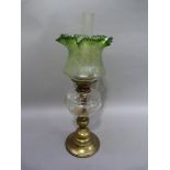 An Edwardian brass oil lamp with clear glass reservoir and English brass burner with acid etched