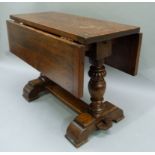 A reproduction oak drop leaf coffee table on lobed baluster supports and flattened stretchers,