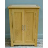 A reproduction oak cupboard enclosed by a pair of panelled cupboard doors, 70cm wide x 102cm high
