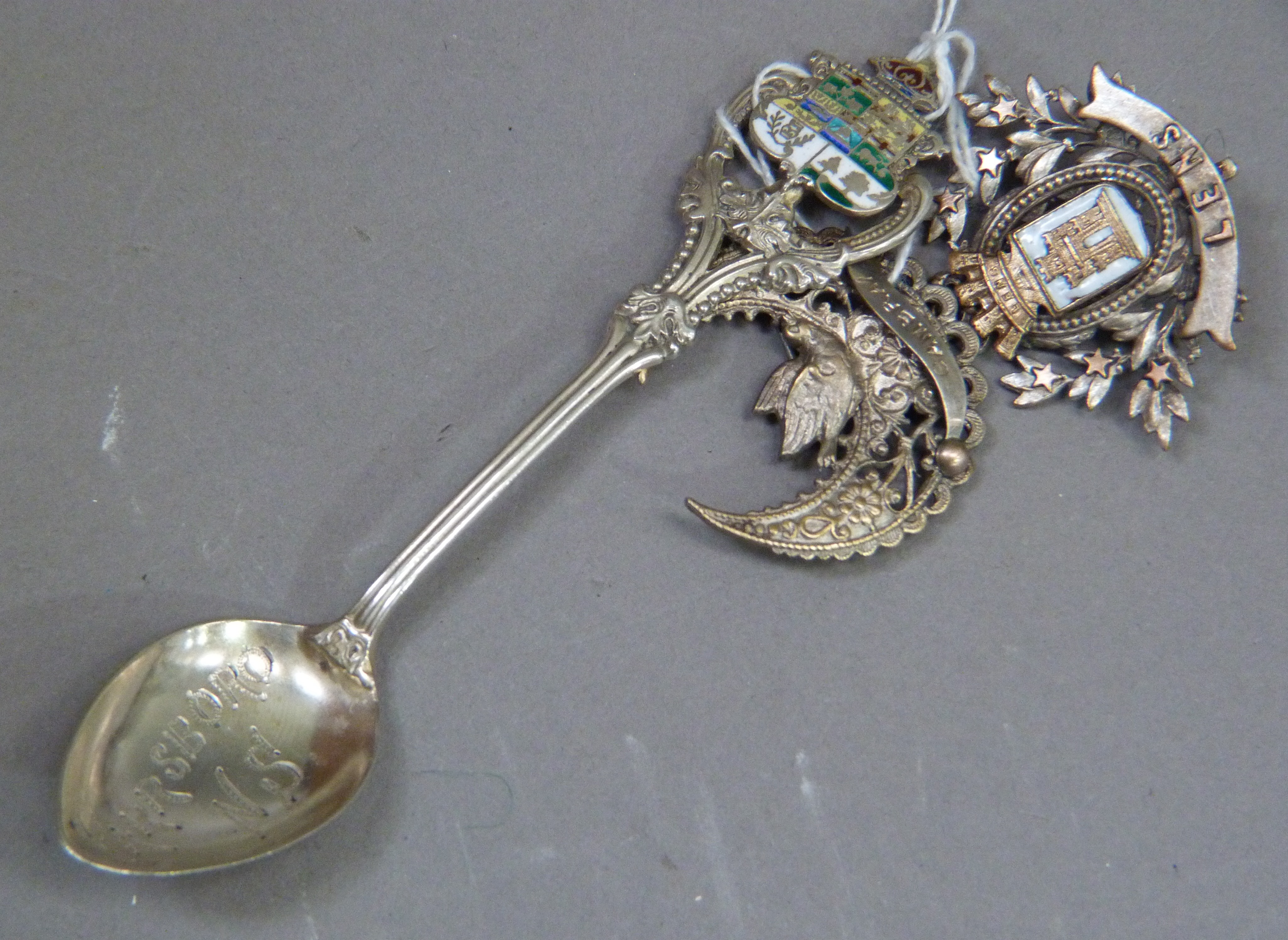 Three items of early to mid 20th tourist ephemera including a base metal Lews brooch, silver