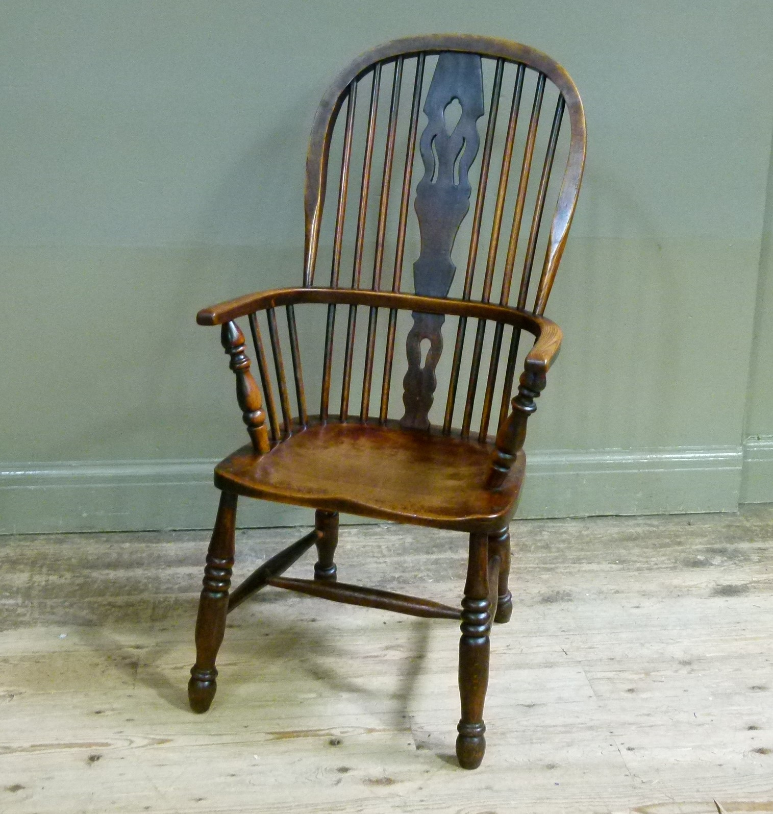 A late 19th century high back Windsor elbow chair with pierced splat, bordered seat on turned legs