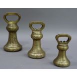 A graduated set of brass bell-shaped weights, comprising 7lbs, 4lbs and 2lbs, 7lbs weight 19cm