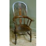 A late Victorian broad arm high back elbow chair with shaped 'christmas tree' splat, scrolling arms,