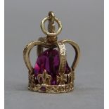 A crown charm in 9ct gold, c.1947, set to the centre with a faceted red paste bead, approximate