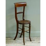 An early Victorian mahogany correction chair the concave back above moulded vertical and