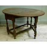 A late 17th century oak gate leg dining table the oval top above pair of drawers, turned baluster