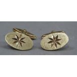 A pair of cufflinks in 9ct gold, the oval star engraved faces with swiveling T bar fittings, total