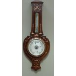 An Art Nouveau mahogany wheel barometer with thermometer inlaid overall with sinuous trails in