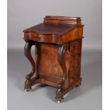 A Victorian walnut davenport of serpentine outline with a raised section for inkwell, pen slide