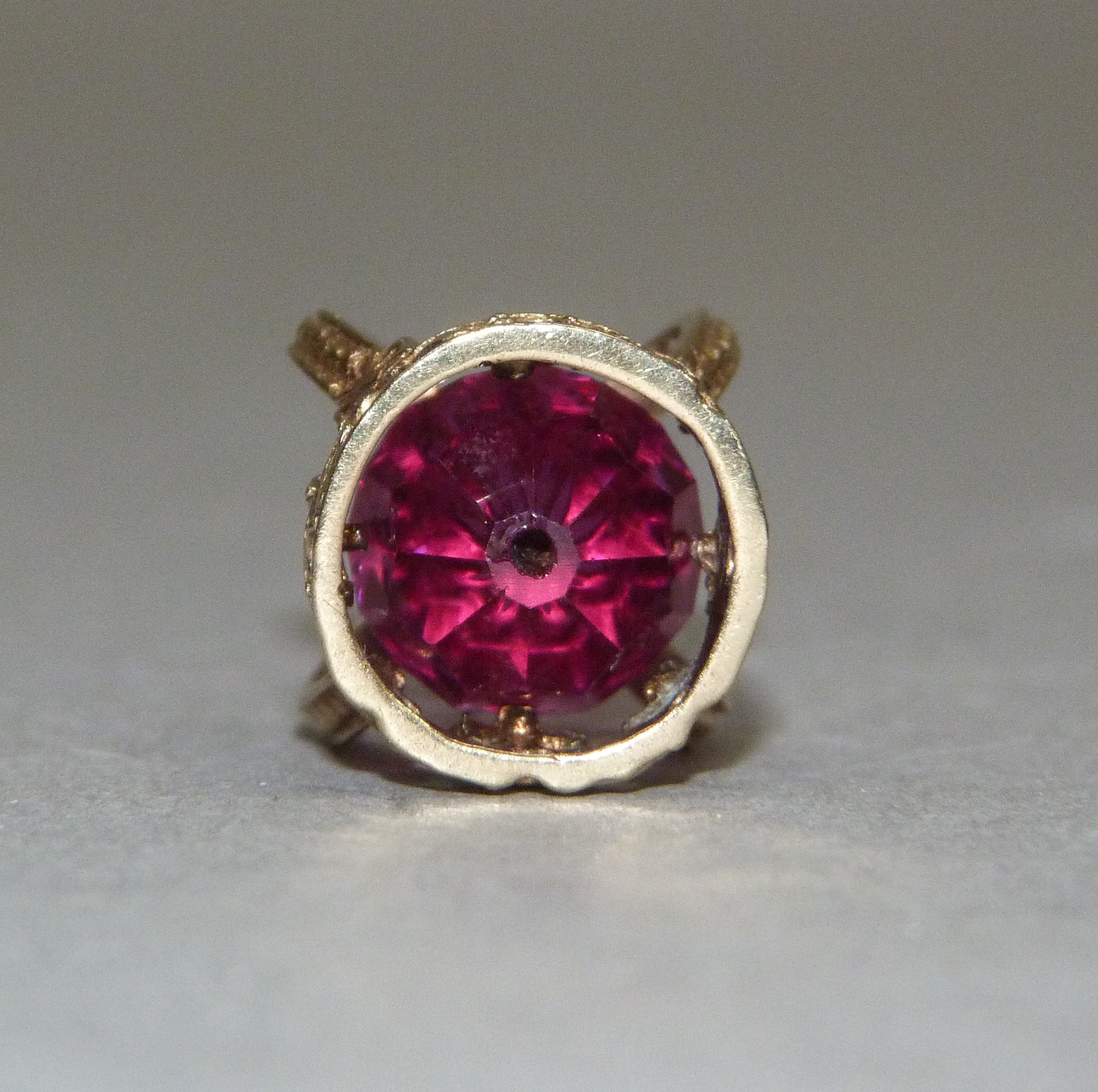 A crown charm in 9ct gold, c.1947, set to the centre with a faceted red paste bead, approximate - Image 3 of 3