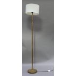 A brass telescopic standard lamp with white cylindrical shade