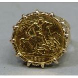 An Edward VII 1907 half sovereign, claw set in a 9ct gold pierced scroll ring mount, total