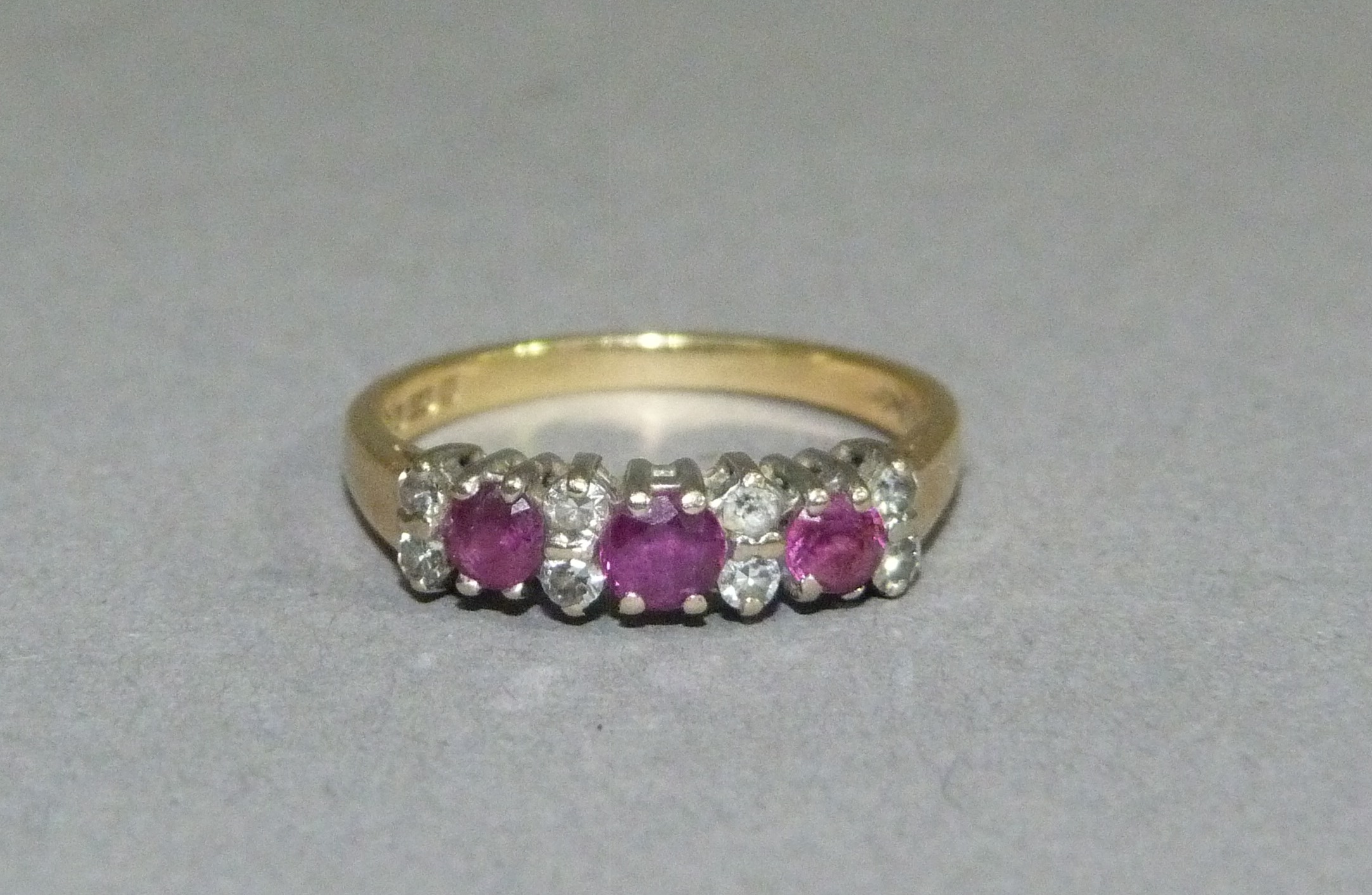 A ruby and diamond ring in 18ct gold, the circular faceted rubies and eight cut diamonds claw set in