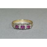 A ruby and diamond ring in 18ct gold, the circular faceted rubies and eight cut diamonds claw set in