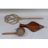 An early 20th century carpet beater, a wooden water ladle, and a pair of bellows