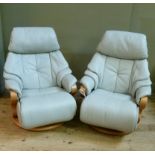 A pair of German Himolla pale grey leather reclining and revolving easy chairs on steam bent frames,