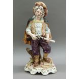 A Capo di Monte style pottery figure of a huntsman the elderly figure with cape, amethyst coloured