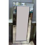 A mirror with bevelled plate and conforming rectangular border plates, 108cm x 47cm