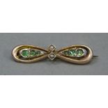 A George V 9ct gold bow brooch set with garnet doublets on seed pearls, approximately 35mm