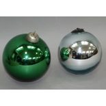 A silver and green witches ball or Christmas ornament, 14cm & 13cm diameter, both with suspension