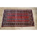A reproduction Bokhara rug, the centre filled with two rows of thirteen octagonal guhls within multi