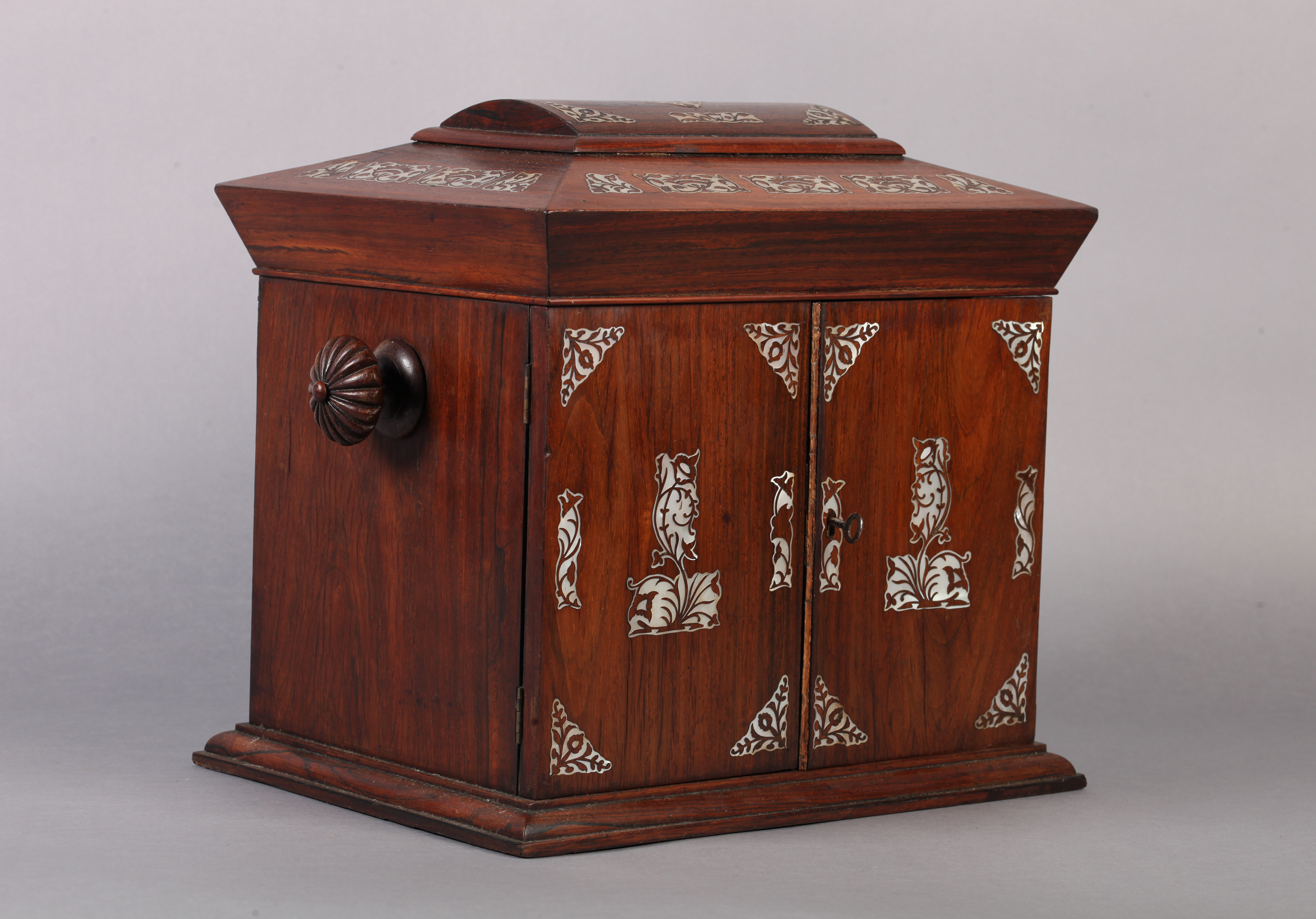 A VICTORIAN MOTHER OF PEARL INLAID ROSEWOOD TABLE CABINET with domed sarcophagus shaped hinged lid