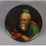 A LATE 19TH CENTURY BLACK PAPIER MACHE CIRCULAR SNUFF BOX, the pull-off lid painted with head and