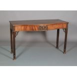 A GEORGE III MAHOGANY SERPENTINE SIDE TABLE, the deep apron centred with a tablet carved in low