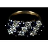 A SAPPHIRE AND DIAMOND CLUSTER RING in 18ct gold, the brilliant cut diamonds and circular faceted