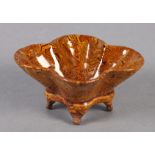 A CHINESE AMBER GLAZED MARBLED EARTHENWARE CENSER of quatrefoil outline on four bracket feet, 10.