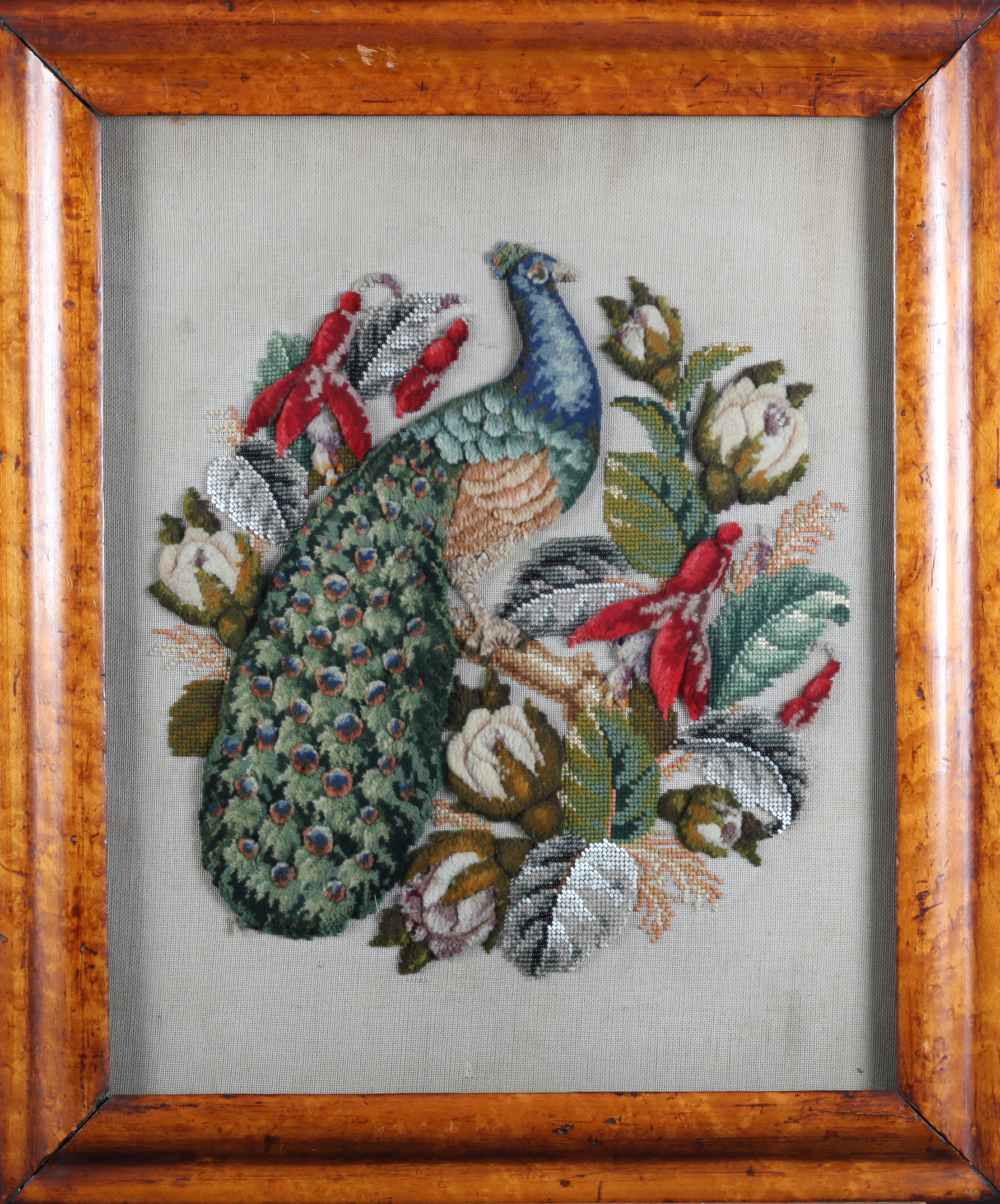 A VICTORIAN PLUSH WOOLWORK PICTURE with glass beadwork leaves of a peacock amidst flowers and