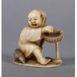 A LATE 19TH CENTURY JAPANESE IVORY NETSUKE of a woodworker, kneeling, his adze beside him and
