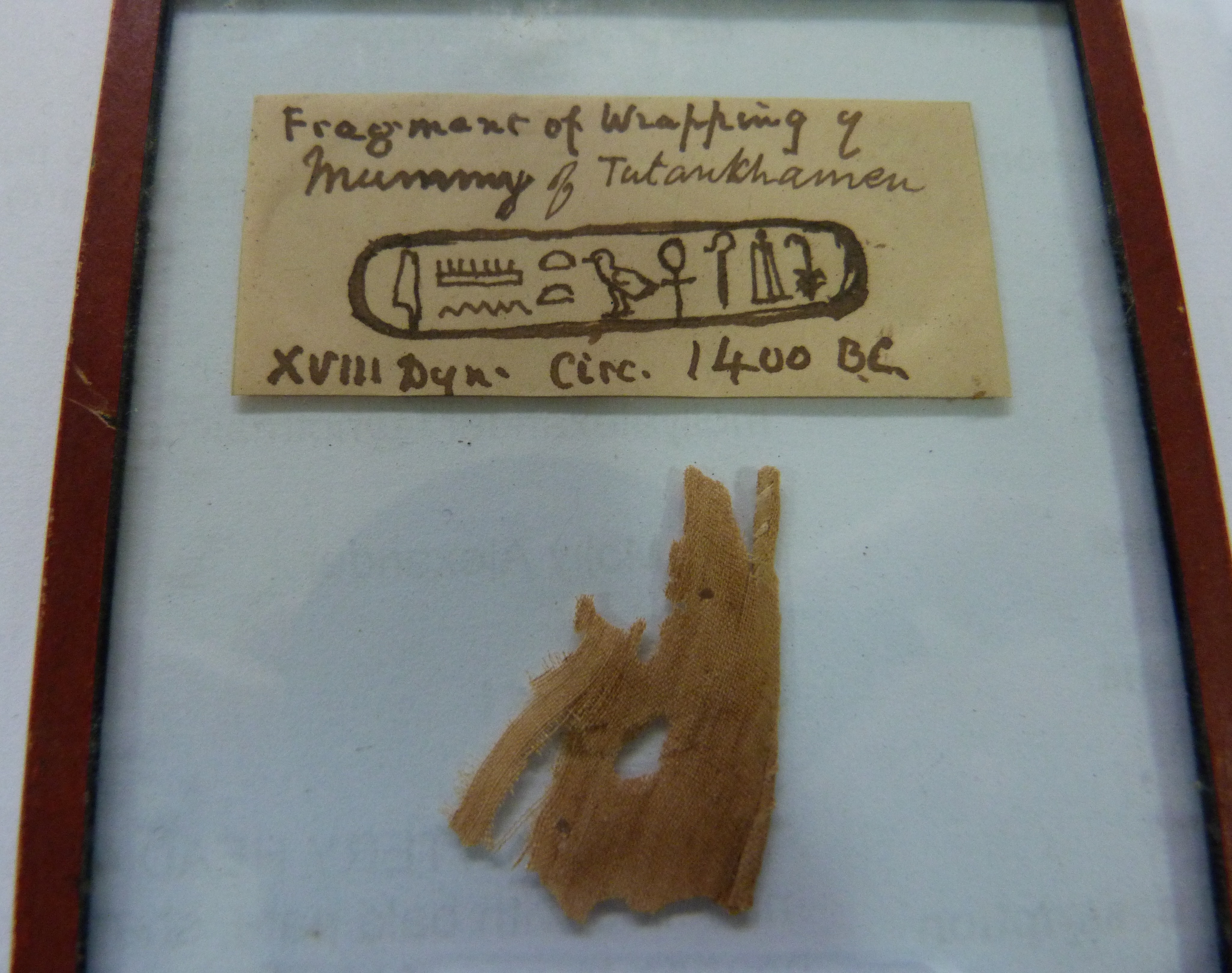 A 'FRAGMENT OF WRAPPING OF MUMMY OF TUTANKHAMEN XVIII DYN, CIRC 1400BC', glass panel with red - Image 4 of 4