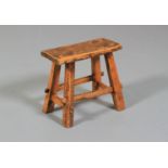 A 19TH CENTURY FRUITWOOD STOOL, rectangular, on four tapered and splayed legs joined by