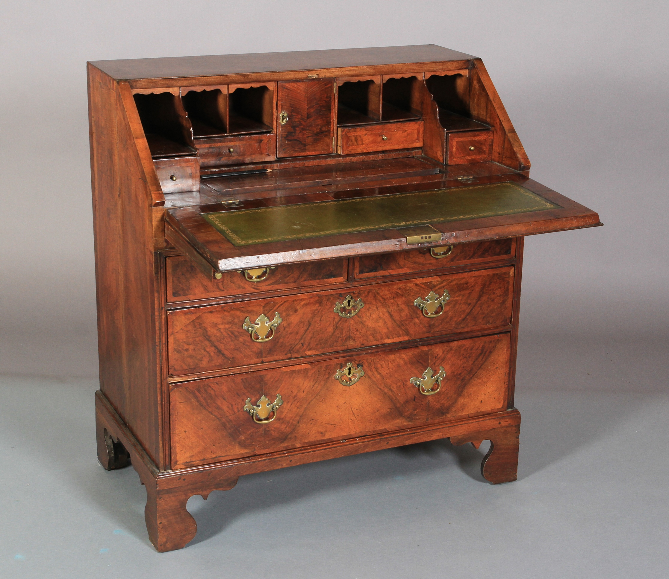 AN EARLY 18TH CENTURY FIGURED WALNUT CROSSBANDED AND BANDED BUREAU having a drop front, the interior