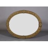 A LATE 19TH CENTURY GILT METAL FRAMED OVAL WALL MIRROR, the frame embossed with a band of