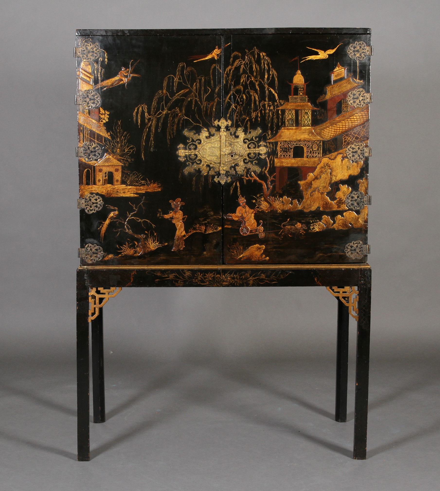 A CHINESE BLACK AND GILT LACQUERED CABINET ON STAND, 19th century, having two doors gilt with